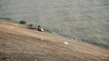 Kamboçya nehrinde adam yıkanır.