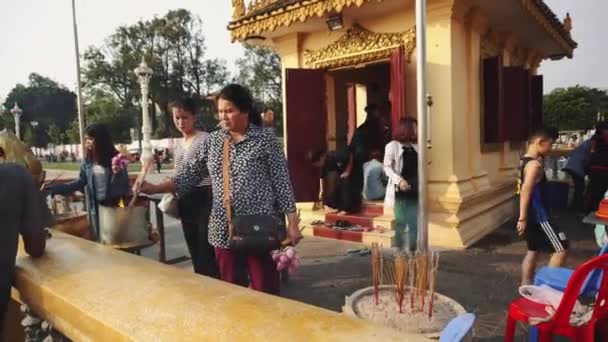 Az emberek egy ázsiai templom közelében imádkoznak. — Stock videók