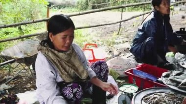 İnsanlar Asya 'daki sokak gıda pazarından deniz ürünleri ve sebze alıp satıyor.