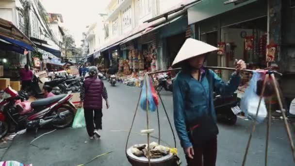 Vendedor en el mercado callejero en el casco antiguo de Hanoi Vietnam. Mujer vestida con lechuga verde vendedora para comer en la calle . — Vídeo de stock