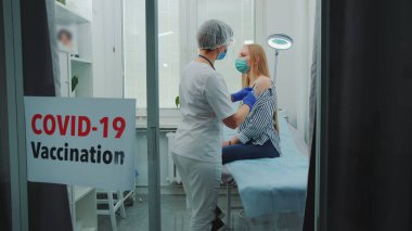 Genç bir kadın hastanede koronavirüs aşısı oluyor.