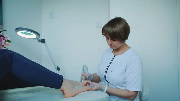 Vrolijke manicure het maken van een hardware pedicure voor vrouw. — Stockfoto