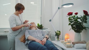 Profesyonel kozmetikçi, genç kadınların yüzünü kabukluyor.