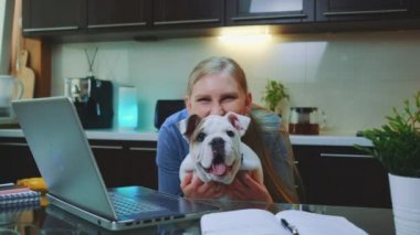 Buldoglu mutlu kadın kameraya bakıyor ve gülümsüyor.