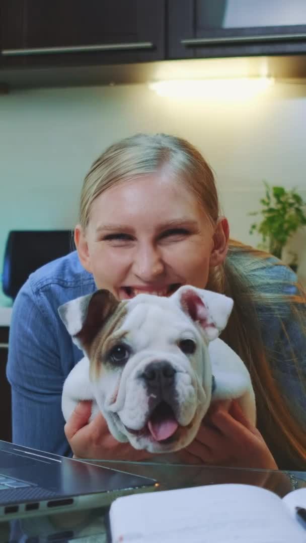 Vídeo vertical: Mulher feliz com um bulldog olhando para a câmera e sorrindo — Vídeo de Stock