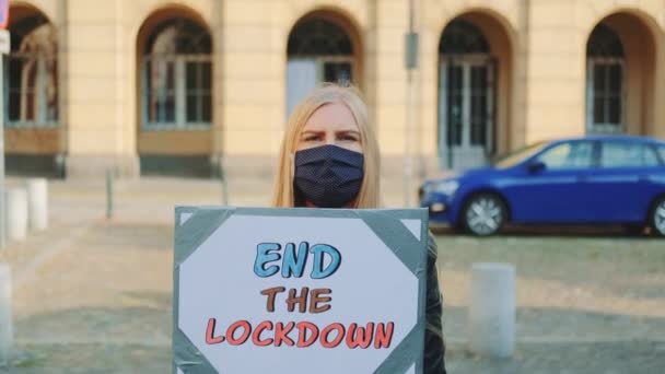 Donna in maschera che chiede di porre fine all'isolamento durante la marcia di protesta — Video Stock