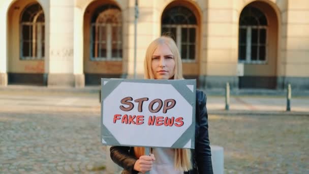 Mujer joven protestando contra noticias falsas — Vídeos de Stock