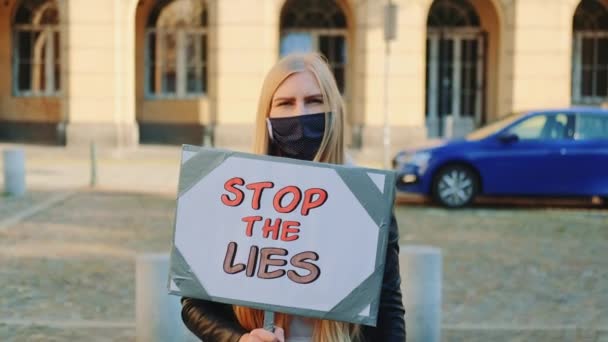 Besorgte Frau in Maske mit Protestbanner fordert Ende der Lügen — Stockvideo