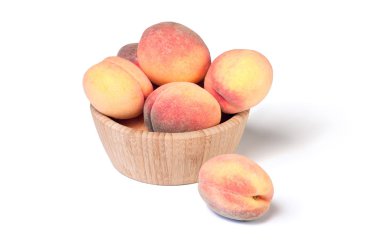 Beyaz arka plan üzerinde izole ahşap kase nazik olgun şeftali.