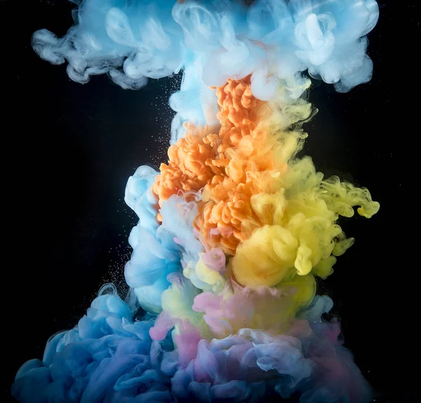 カラフルな虹色の塗料は 水に混合物の上から落ちる 水中で渦巻くインク — ストック写真