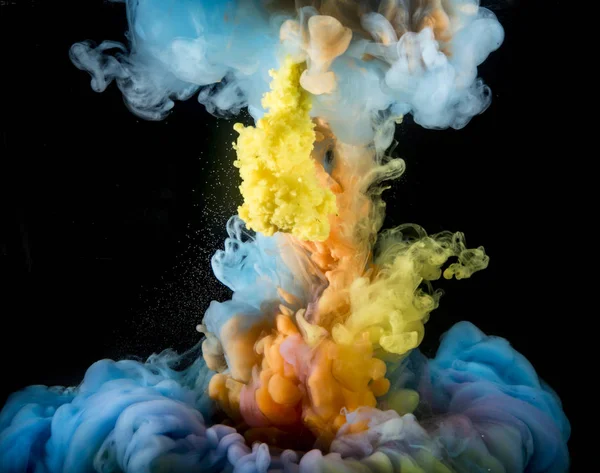 Colorful rainbow paint drops from above mixing in water. Ink swirling underwater.