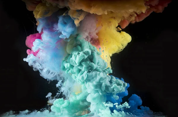 Colorful rainbow paint drops from above mixing in water. Ink swirling underwater.