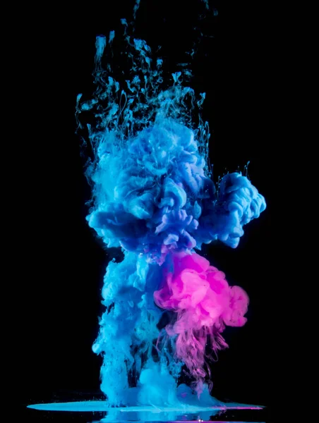 Le gocce di vernice dall'alto mescolandosi in acqua. Inchiostro vorticoso sott'acqua. Rosa, colori blu — Foto Stock