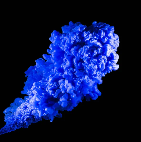 Blaue Farbtropfen von oben, die sich mit Wasser vermischen. Tinte wirbelt unter Wasser — Stockfoto