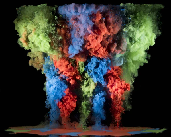 Colorful rainbow paint drops from above mixing in water. Ink swirling underwater