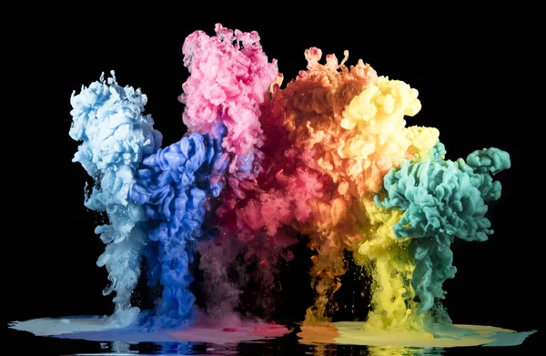 Kleurrijke regenboogverf druppels van boven mengen in water. Inkt wervelend onder water — Stockfoto