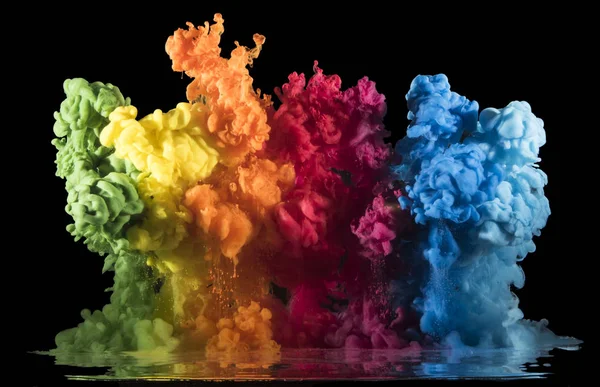 Von oben fallen bunte Farbtropfen, die sich mit Wasser vermischen. Tinte wirbelt unter Wasser. — Stockfoto