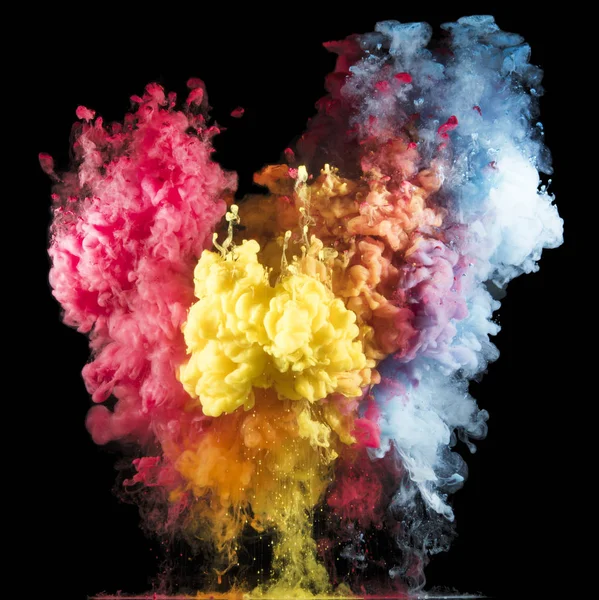 Colorful paint drops from above mixing in water. Ink swirling underwater.