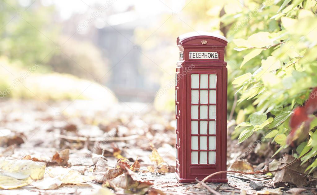 Traditional british vintage red phone booth in the autumn park