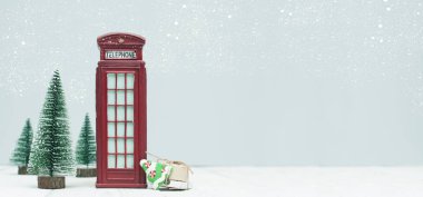 Banner ile Noel süsleri, oyuncak kırmızı telefon kulübesi, ağaçlar, açık renkli hediyeler