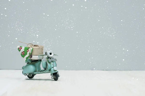 Vintage toy motorbike with christmas gifts and tree on grey background