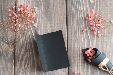 Buket pembe çiçek ve tebrik kartı düz ahşap arka plan yattı