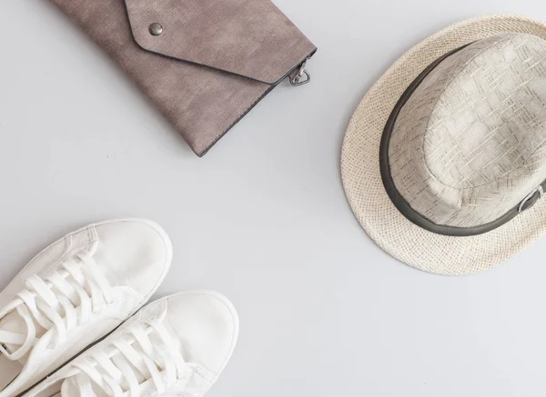 Flat lay travel items - shoes, hat and purse  on grey background