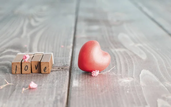 古い木製手紙単語 Love とリビング ルームのテーブルの上の赤いハートの形でバレンタインデーの室内装飾 — ストック写真