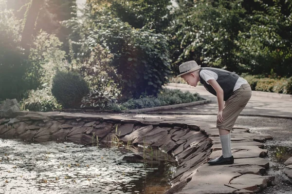 Хлопчик стоїть біля лісового озера — стокове фото