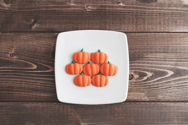 Orange pumpkin candies on wooden table — Stock Photo, Image