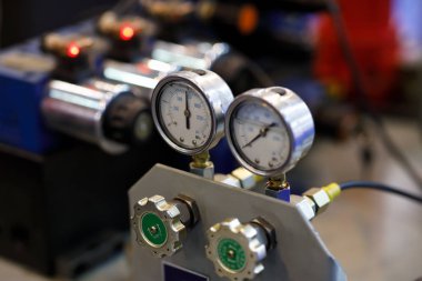 Hydraulic equipment with pressure gauges on an industrial machine. Selective focus. clipart