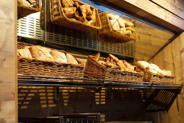 Baskets with different types of bread on the shelf — Stock Photo, Image