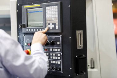 Cnc makine operatörü bir kontrol paneli ile çalışıyor