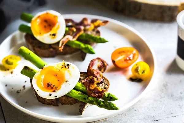 Speck, gebratener Spargel und weich gekochtes Ei auf Roggenbrot-Sandwic — Stockfoto