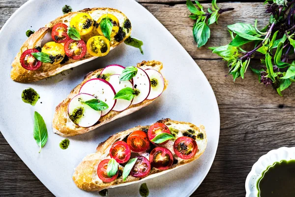 Tomate Cherry y Bruschetta de rábano con aceite de albahaca , —  Fotos de Stock