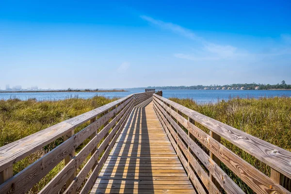 Um calçadão muito longo cercado por arbustos em Gulf Shores, Alabama — Fotografia de Stock