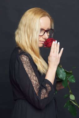 Stüdyoda fotoğraf çekimi. Kitabı ve gülü olan beyaz bir kadın. Harika.