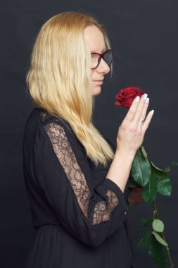 Stüdyoda fotoğraf çekimi. Kitabı ve gülü olan beyaz bir kadın. Harika.