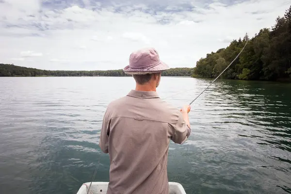 人的后方看法是飞行钓鱼从小船在湖 — 图库照片