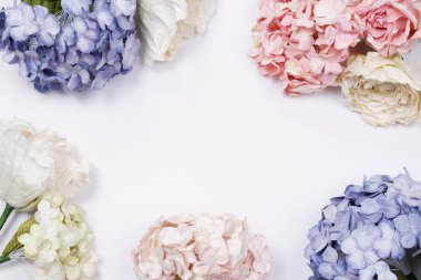 Çerçeve ve bej pembe güller, yeşil yapraklar, mavi ortanca dalları beyaz zemin üzerine yaptı. Düz yatıyordu, en iyi görünüm. Düğün'ın arka plan. Valentine'nın arka plan kopya alanı ile.