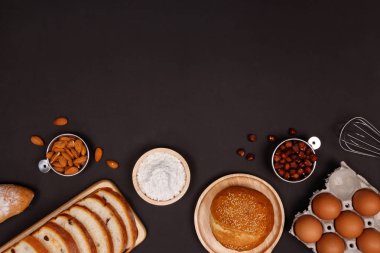 Ev yapımı ekmek ya da topuz, kruvasan ve ekmek malzemeler, un, badem fındık, fındık, yumurta koyu arka plan, fırın arka plan çerçeve, yemek kahvaltı kavramı. Düz yatıyordu, en iyi görünüm ve kopya alanı