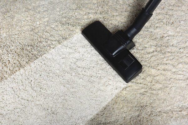 close-up view of cleaning white carpet with professional vacuum cleaner 