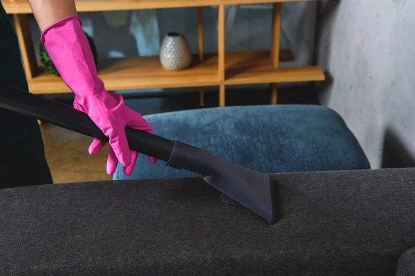 橡胶手套清洁家具用真空吸尘器的人的部分看法 — 图库照片