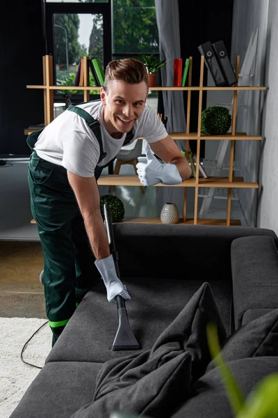 Sorrindo Jovem Limpeza Empresa Trabalhador Limpeza Sofá Com Aspirador Mostrando — Fotografia de Stock