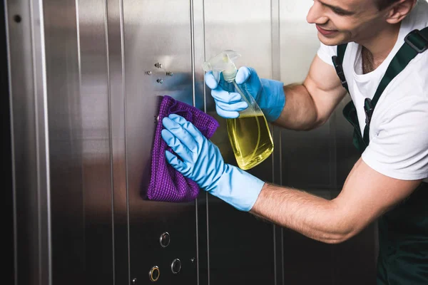 Recortado Disparo Sonriente Joven Trabajador Limpieza Ascensor Con Trapo Detergente — Foto de Stock