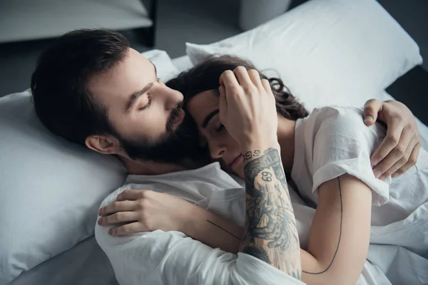 Beautiful Young Tattooed Couple Embracing While Lying Bed Home — Stock Photo, Image