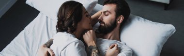 birbirine bakarak ve evde yatakta yatan süre kucaklayan genç Çift