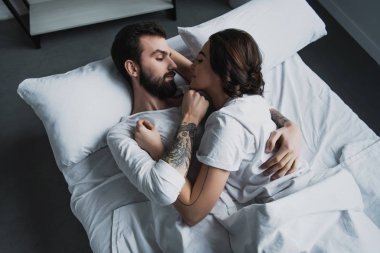 evde yatakta yatan süre kucaklayan pijama çekici genç Çift