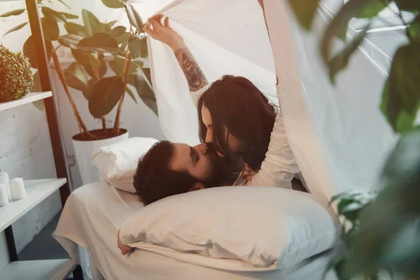Piękna Młoda Para Całować Leżąc Łóżku Pod Koc Sypialni — Zdjęcie stockowe