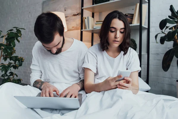 Beautiful Young Couple Pajamas Lying Bed While Using Laptop Smartphone — Stock Photo, Image